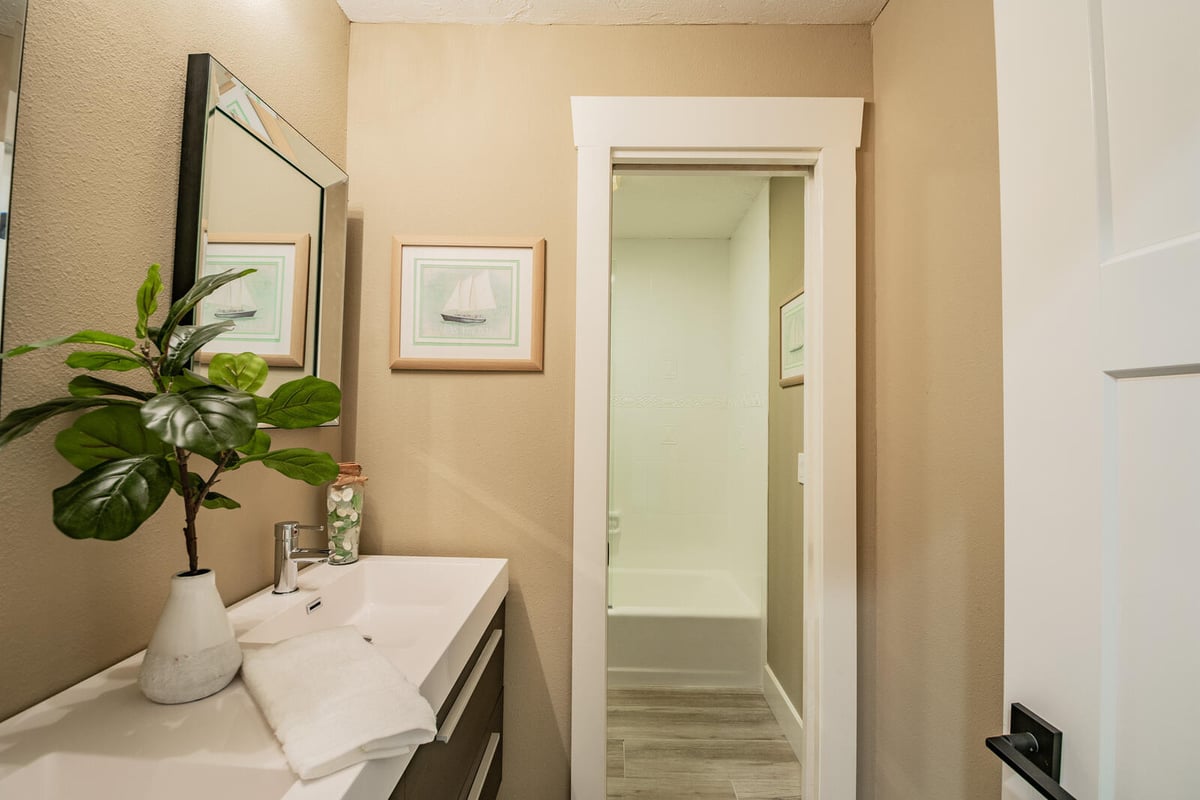 avenida madera guest bathroom with vanity and shower hallway