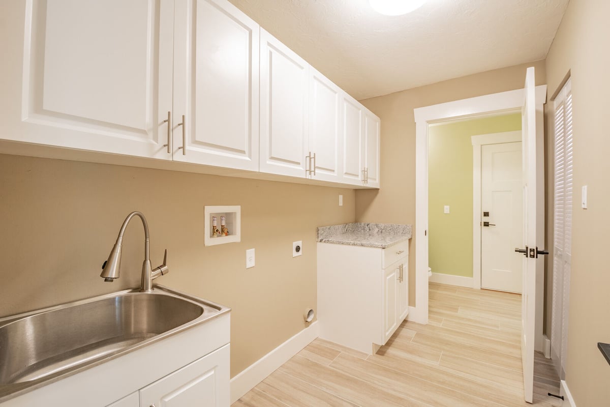 avenida madera laundry room with sink and granite counter
