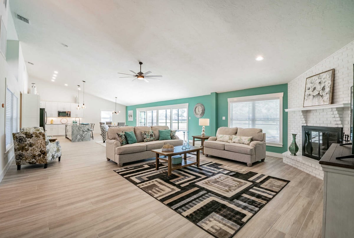 avenida madera living room wide view with kitchen and fireplace
