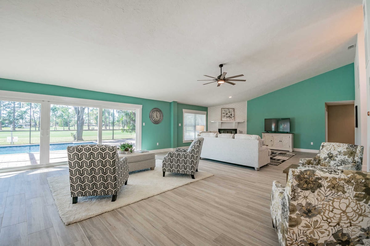 avenida madera living room with teal wall and pool view
