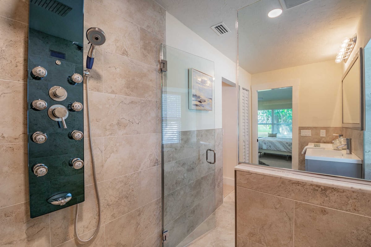 Avenida Madera primary bathroom shower panel with bedroom reflection