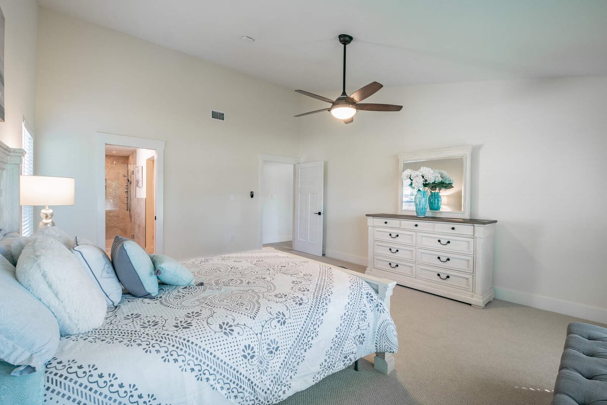 avenida madera primary bedroom with blue bedding and ensuite door