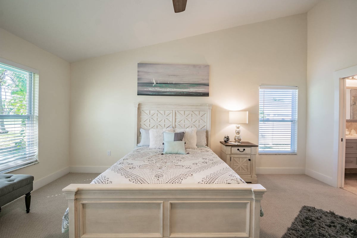 avenida madera primary bedroom with headboard and coastal art