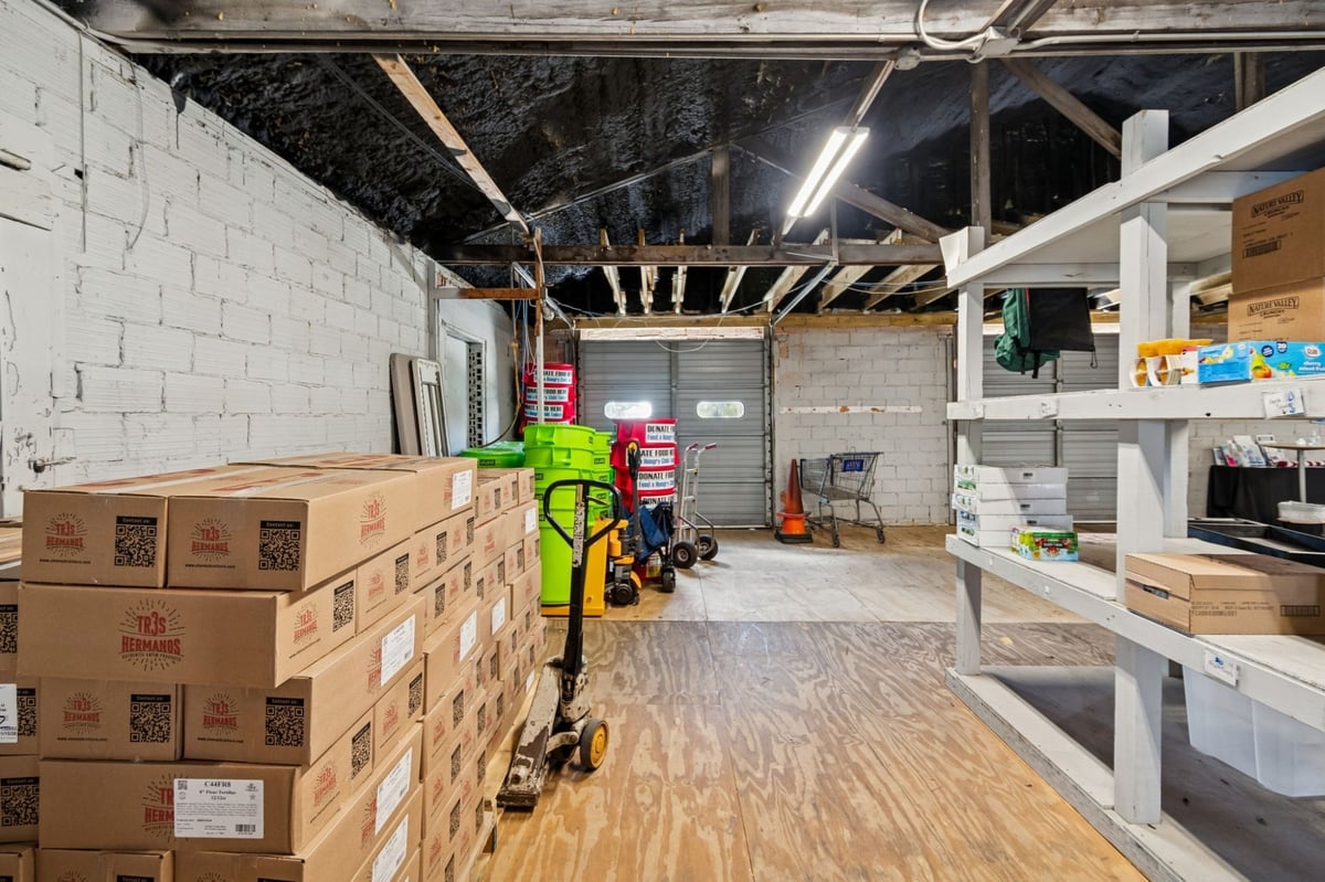 Interior Commercial Warehouse Space Stacked Food Boxes Shelving Pallet Jack Garage Doors