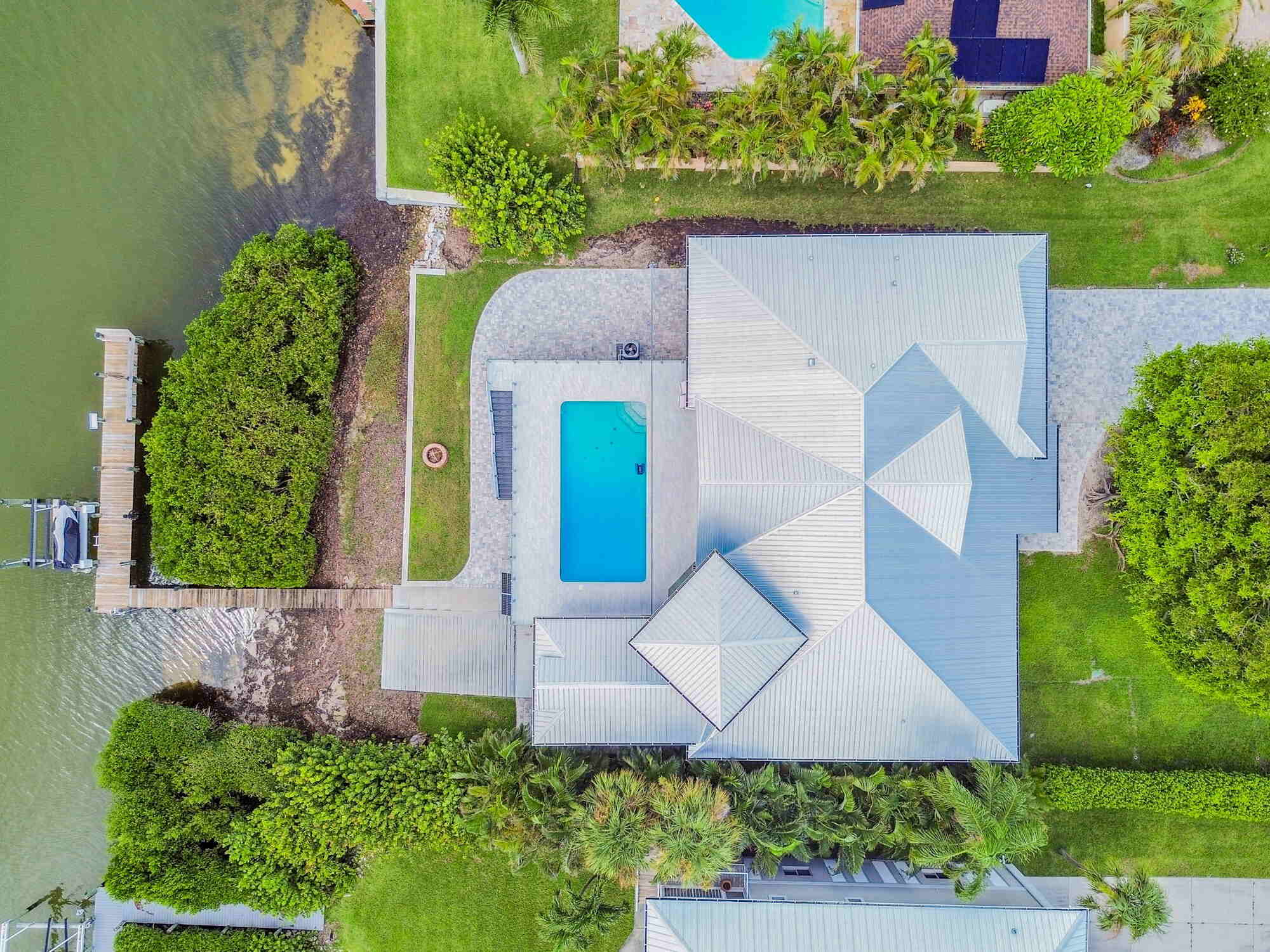 Aerial view of Bradenton custom home with waterfront dock and pool by Adkins Building & Construction. Aerial view of Bradenton custom home with waterfront dock and pool by Adkins Building & Construction.