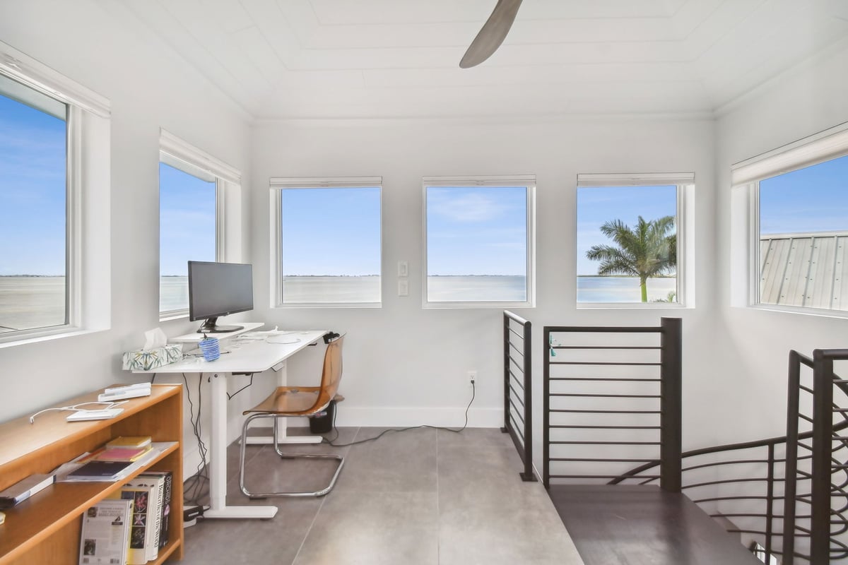 Bright home office with wraparound windows and coastal views in Bradenton, FL by Adkins Building & Construction.