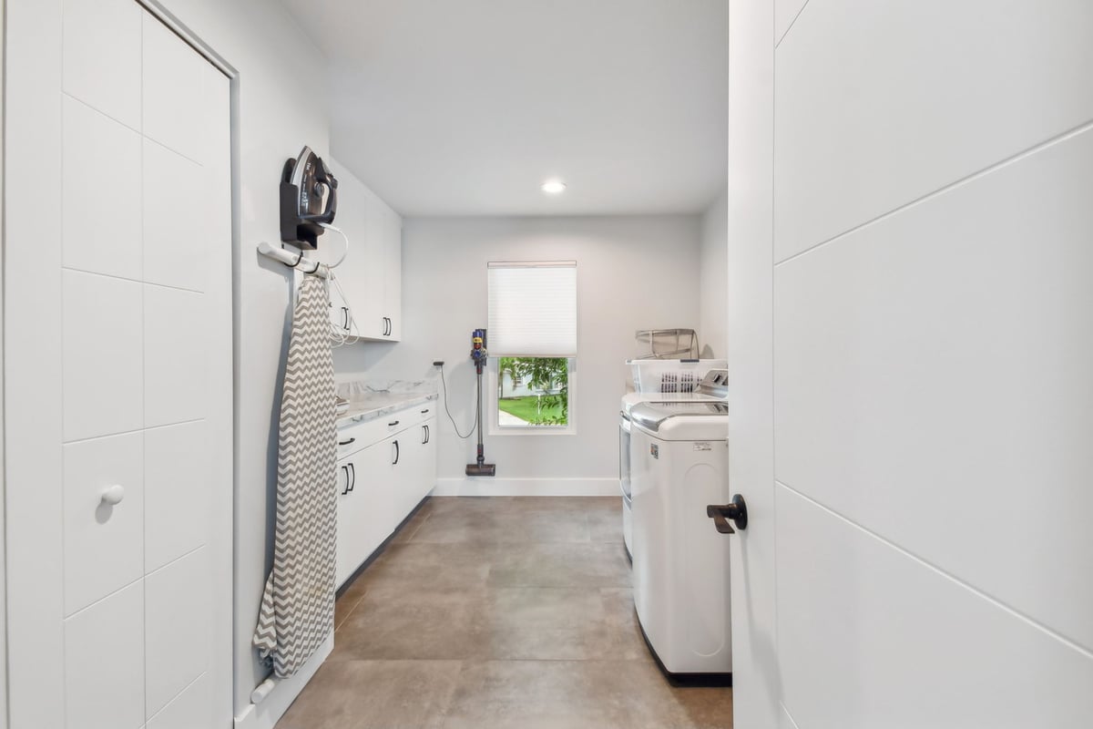 Bright laundry room with custom cabinets and modern appliances by Adkins Building & Construction in Bradenton, FL.