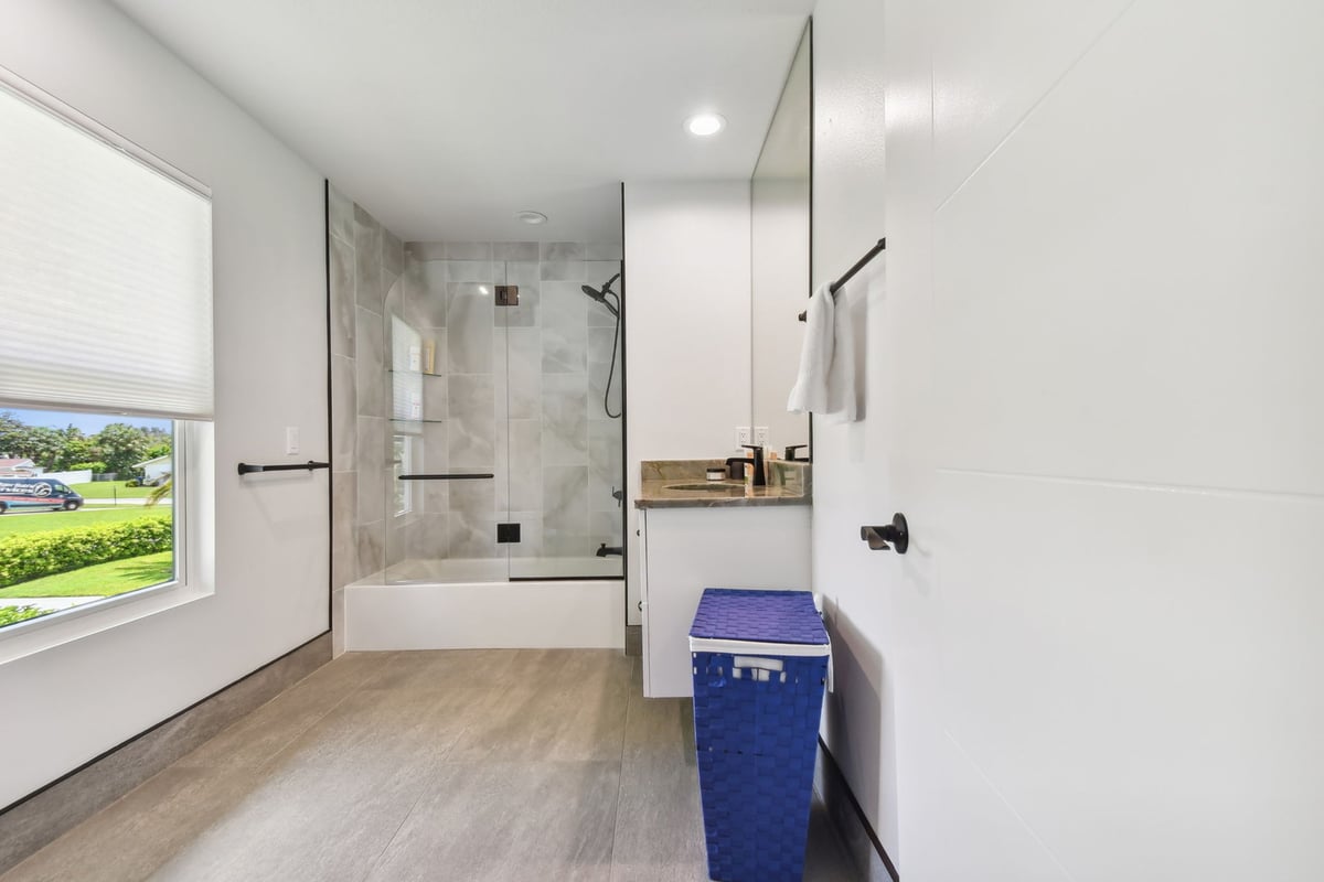 Custom bathroom with walk-in shower and large window by Adkins Building & Construction in Bradenton, FL.