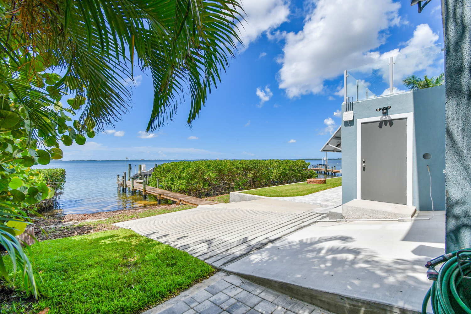 Custom concrete boat ramp and private dock leading to waterfront in Bradenton, FL by Adkins Building & Construction.