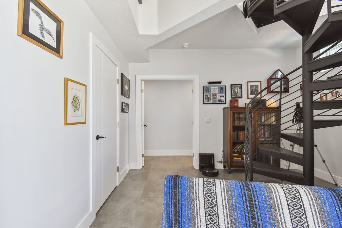 Custom hallway design with spiral staircase and personal gallery wall by Adkins Building & Construction in Bradenton, FL.