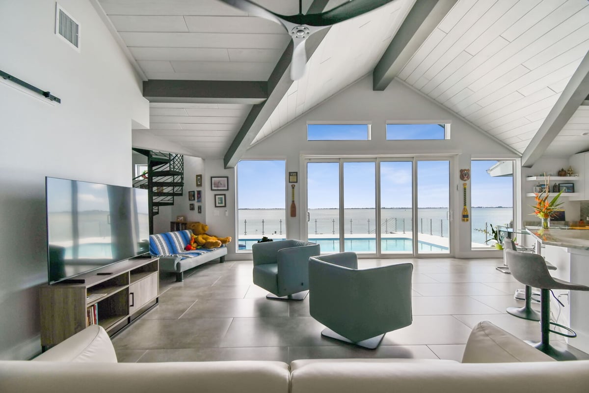 Custom-designed patio with glass railing and seating in Bradenton, FL by Adkins Building & Construction. - 8