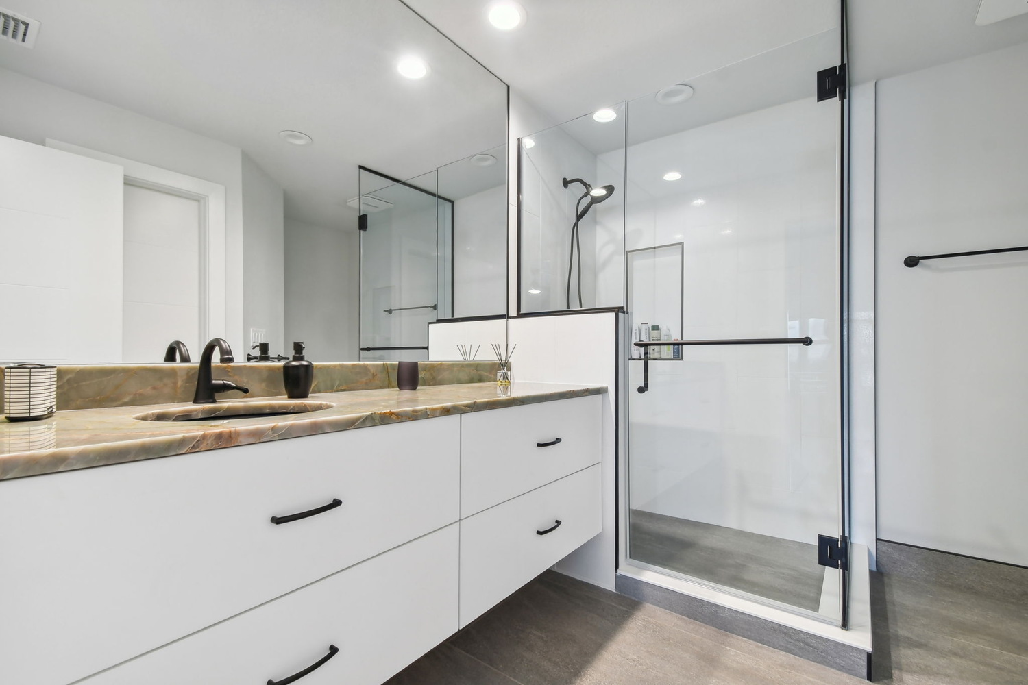 Modern bathroom renovation with glass walk-in shower and stone countertop in Bradenton, FL by Adkins Building & Construction.