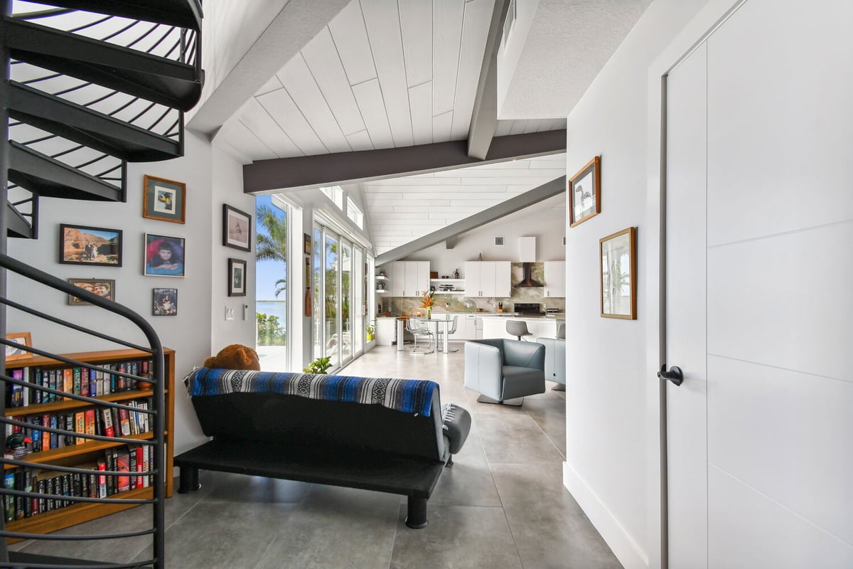 Open-concept interior with spiral staircase and kitchen view in Bradenton, FL custom home by Adkins Building & Construction.