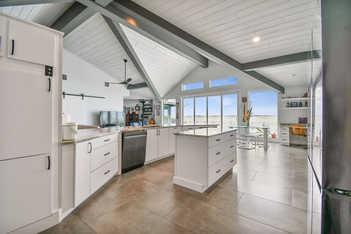 Open-concept kitchen and dining area with vaulted ceilings in custom Bradenton home by Adkins Building & Construction. - 6