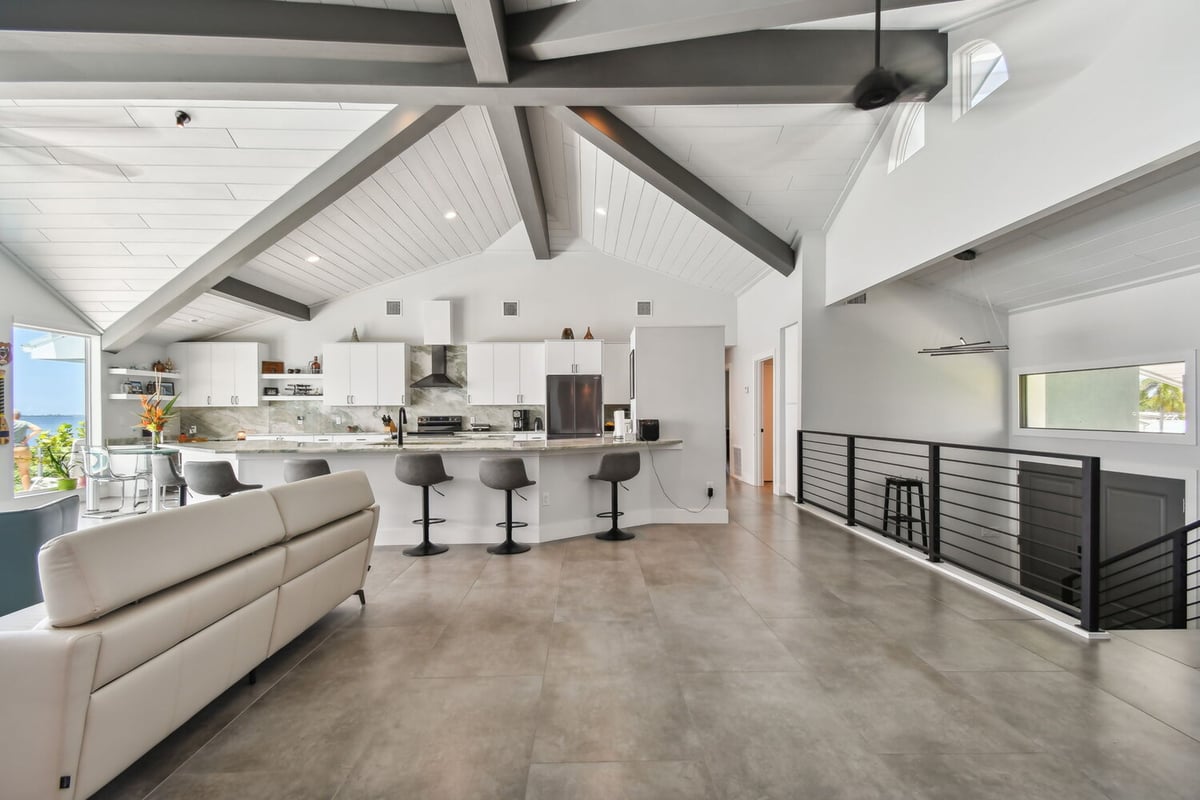 Open-concept kitchen and living space with vaulted ceiling in Bradenton, FL custom home by Adkins Building & Construction.