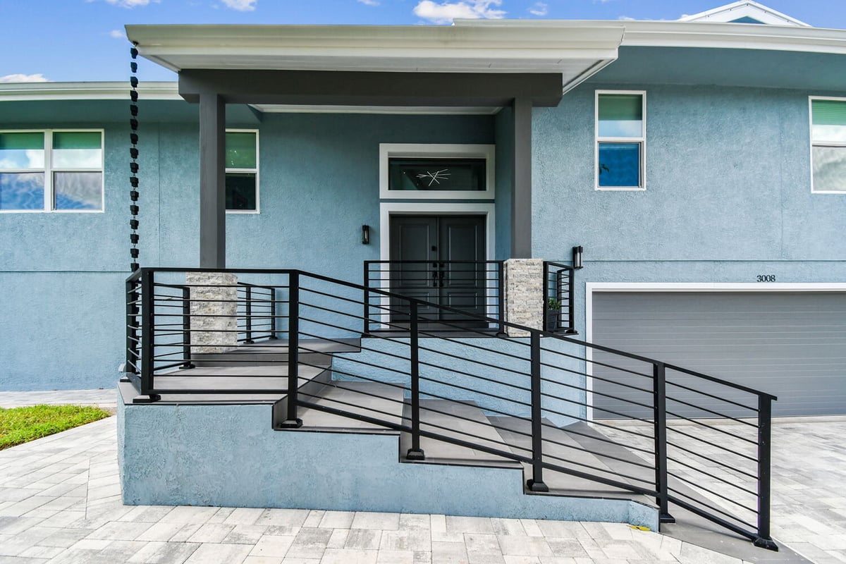 Side front view of completed custom home with tropical landscaping by Adkins Building & Construction in Bradenton. - 3