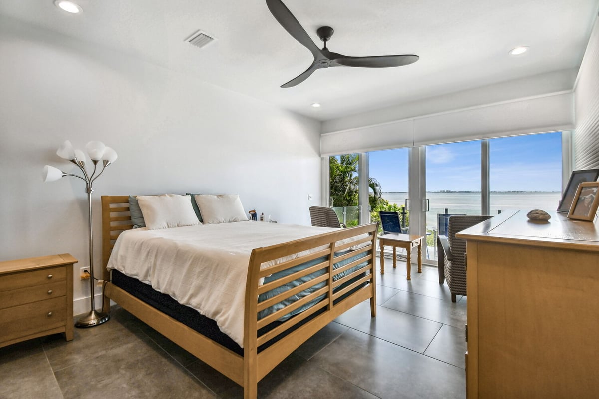 Waterfront master bedroom with private balcony and glass doors by Adkins Building & Construction in Bradenton, FL.