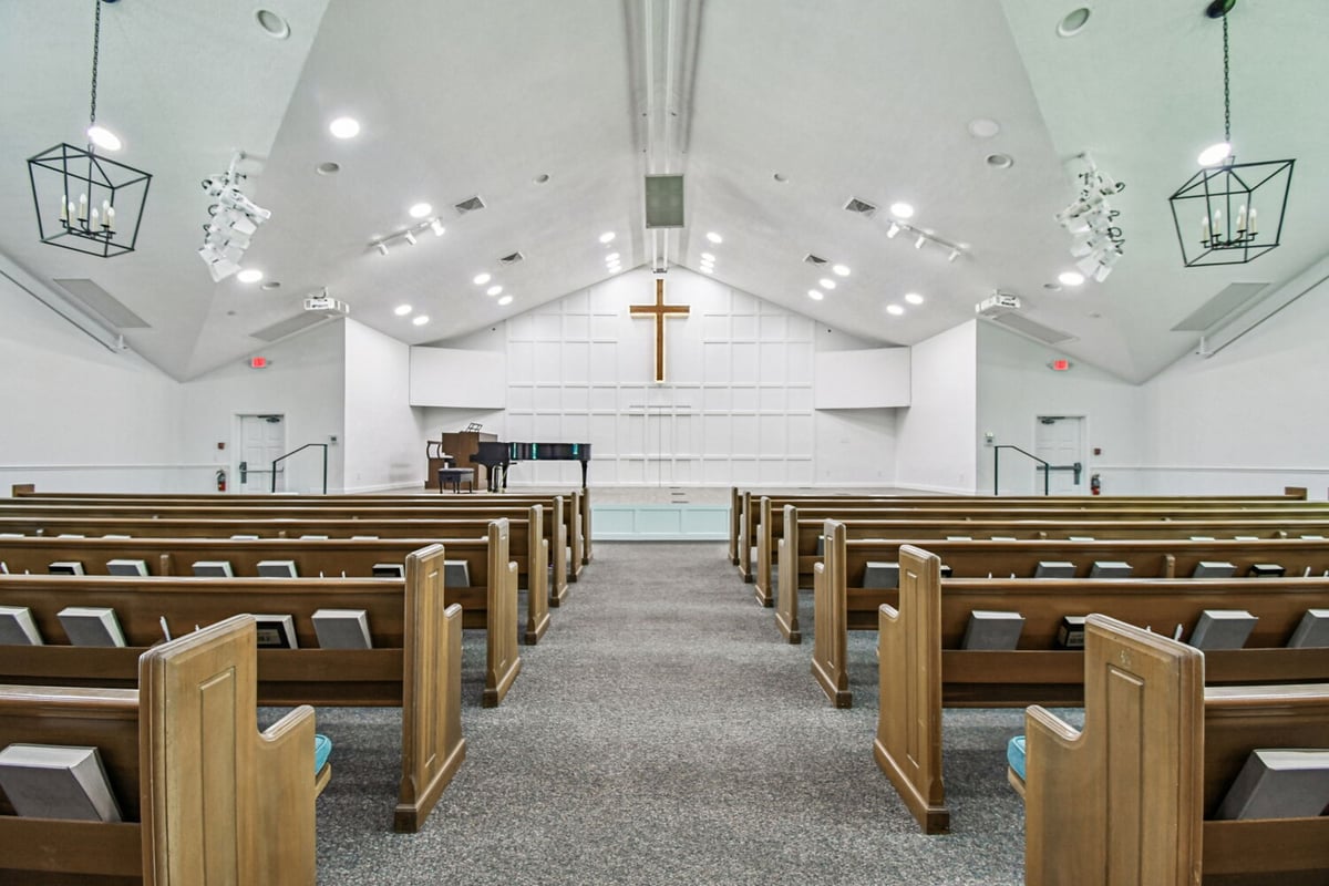 Church interior with central aisle and cross detail in Anna Maria custom home project by Adkins