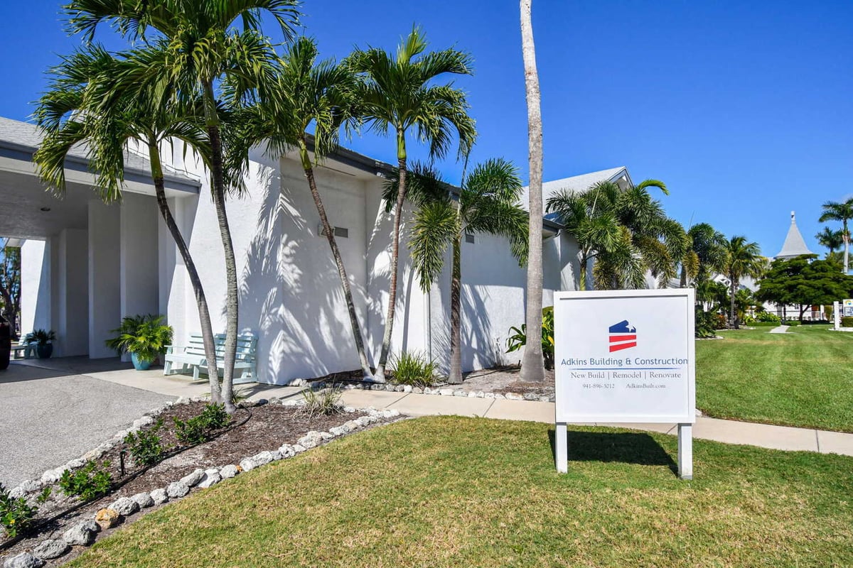 Exterior view of Adkins Building & Construction project with palm trees and company sign in Anna Maria, FL