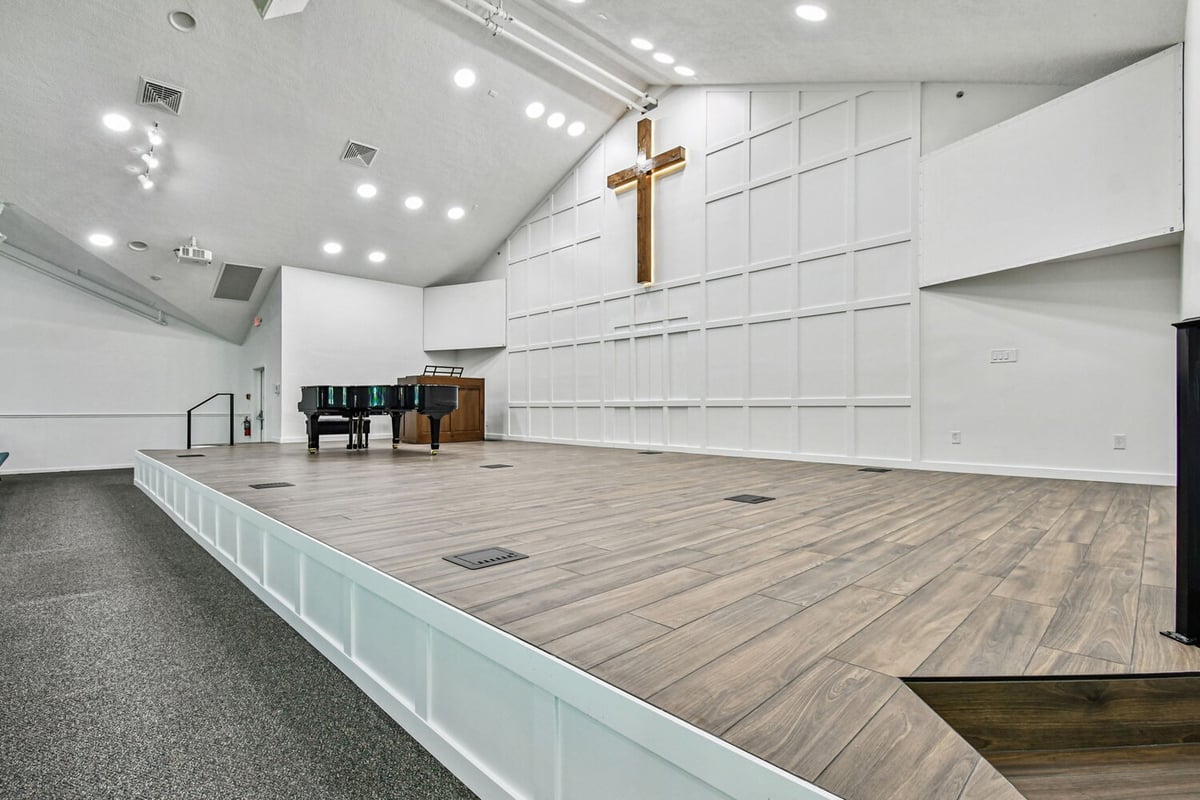Wide-angle view of custom stage with wood flooring in Anna Maria church by Adkins Building & Construction