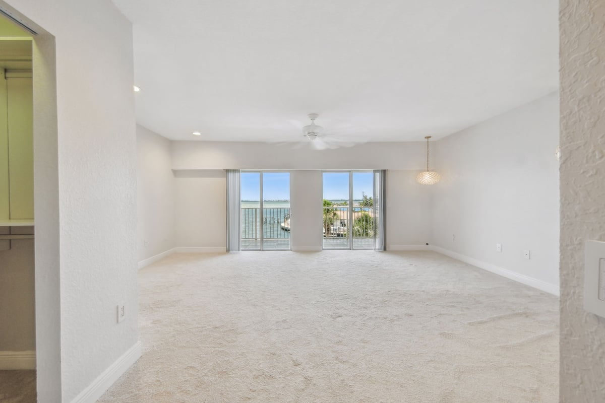 Bright living space with sliding glass doors and water views in Bradenton, FL custom home by Adkins Building & Construction.