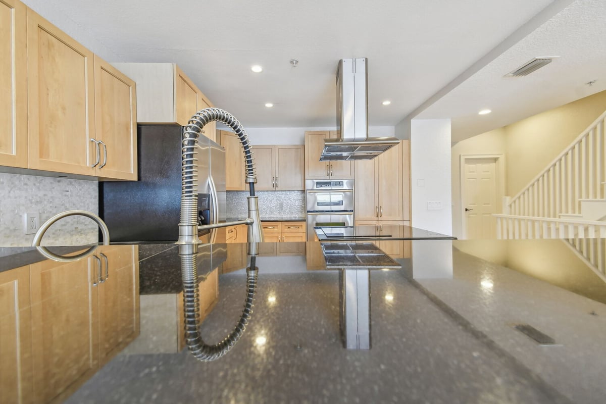 Close-up of a modern kitchen faucet and island countertop in a Bradenton, FL custom home by Adkins Building & Construction.