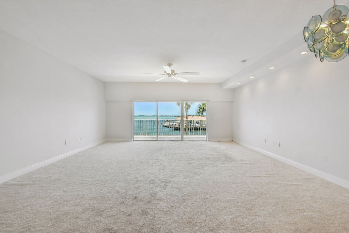 Open living area with sliding glass doors leading to waterfront balcony in Bradenton custom home by Adkins Building & Construction.