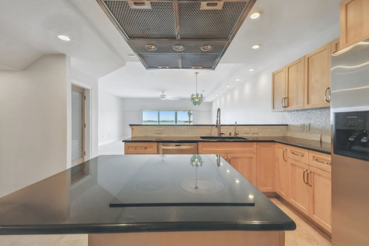View from kitchen island into open living area with water views in a Bradenton custom home by Adkins Building & Construction.