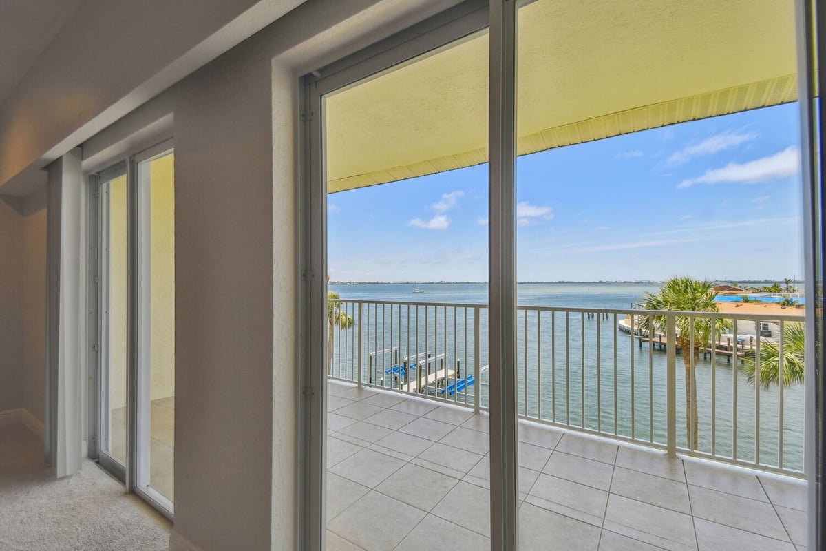 Waterfront scene through sliding glass doors in custom Bradenton home by Adkins Building & Construction.