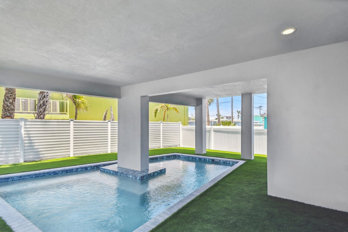 Modern pool and fenced yard of custom home in Bradenton, FL by Adkins Building & Construction