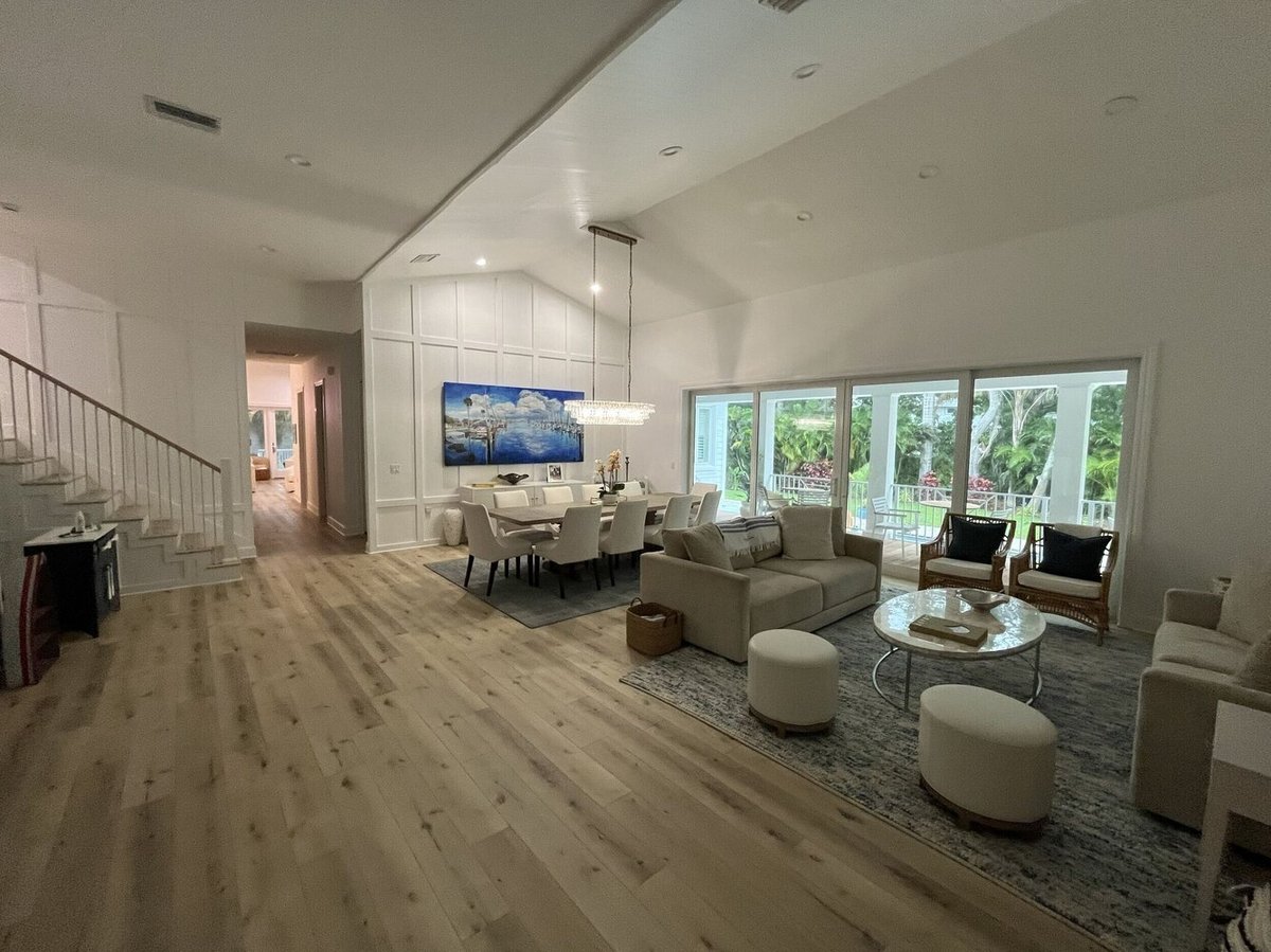 Modern living and dining room completed with custom finishes and glass doors in Anna Maria, FL