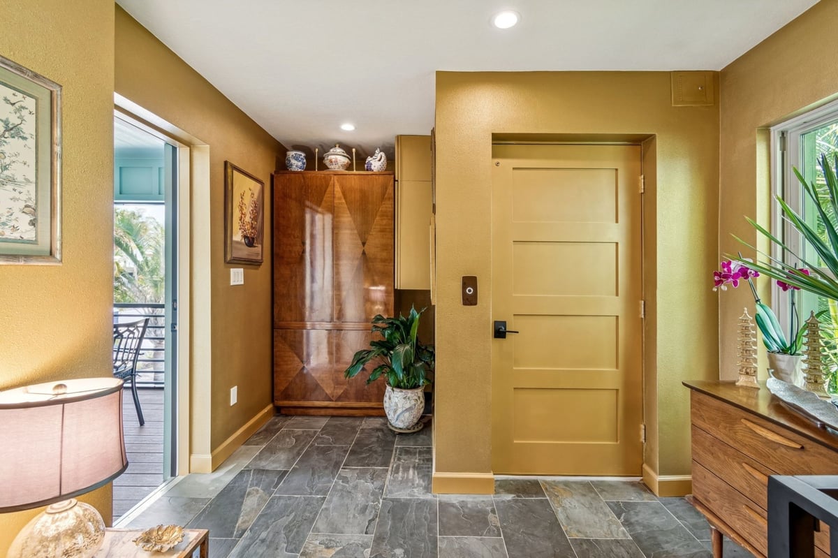 Interior Upper Level Foyer Gold Walls Elevator Door Wood Armoire