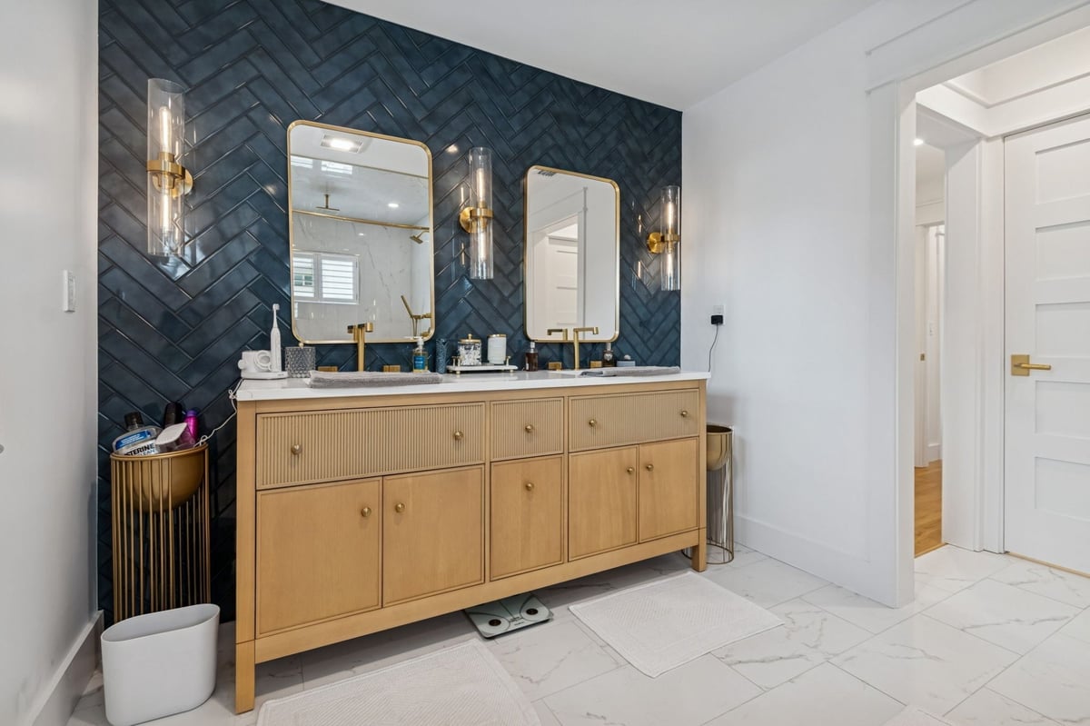 Interior Primary Bath Double Vanity Navy Herringbone Tile Gold Mirrors Sconces