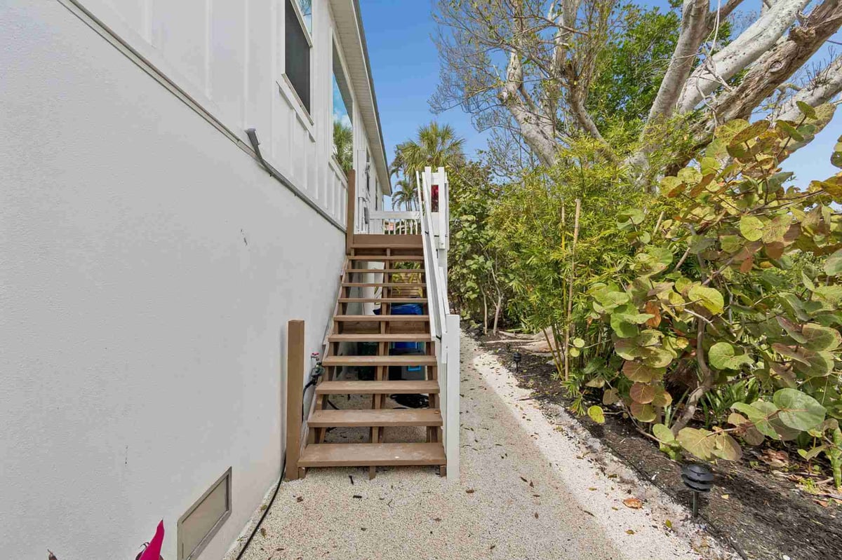 longboat-key-new-home-exterior-side-staircase-tropical-landscaping